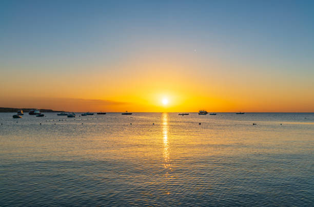 Sunrise over the sea. Panoramic seascape. Burning sky and shining golden waves. Sun over sea
