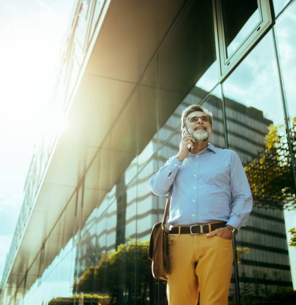 istock Handsome senior businessman standing at street and using smart phone for communication. Modern buildings in background. 2170906477