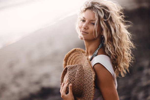 Carefree woman day dreaming during summer day on the beach. Copy space.