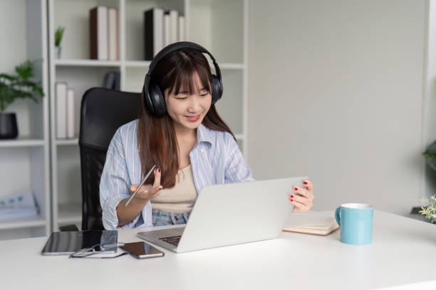 istock Engaged Woman Participating in Online Class with Headphones 2170914408