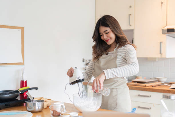 istock Joyful Woman Using Mixer While Following Online Recipe 2170914544