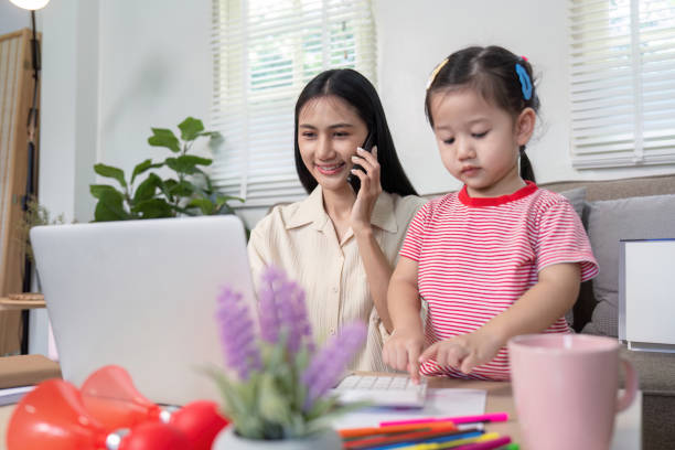 istock Busy Mother on Phone While Toddler Uses Laptop 2170914691