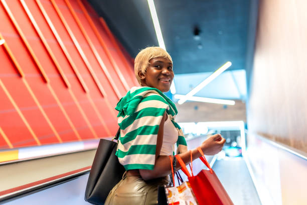 istock African woman using mechanical escalator in a shopping mall 2170915895