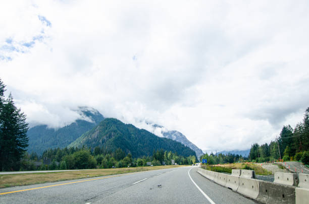 Highway in Hope  BC, Canada with cloud covered mountains in the background