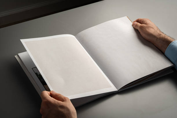 istock Close Up of Person's Hands Holding Open Book While Sitting 2170916547