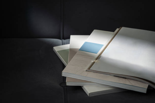 Stack of Magazines on a Black Leather Couch in Soft Light close up