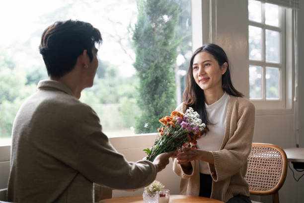 istock Couple Sharing a Bouquet Near Sunlit Window 2170917191