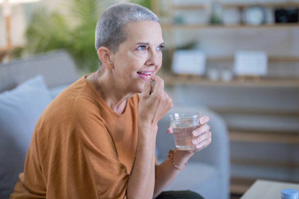 istock Elderly Woman Smiling While Taking Medication with Water 2170917587