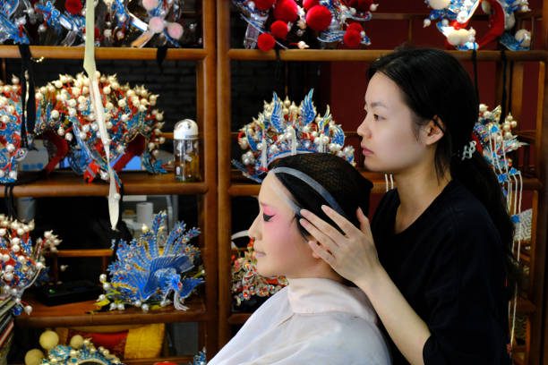 An makeup artist is makingup for an opera actress