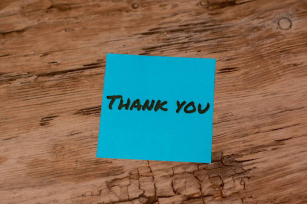 istock Blue thank you note on a wooden desk. 2170921113