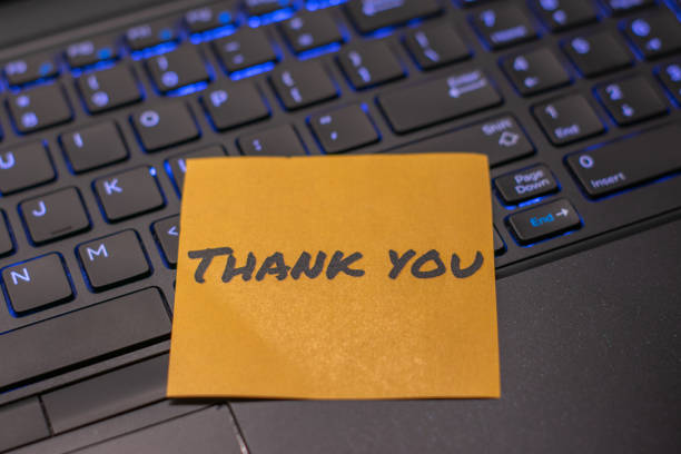 istock Orange thank you note on the illuminated keyboard of a modern laptop. 2170921138