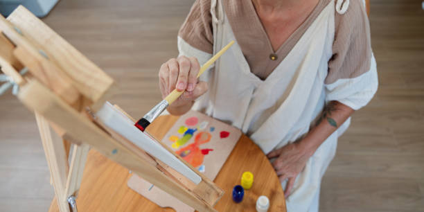 istock Elderly art enthusiast creating vibrant piece at canvas 2170921861