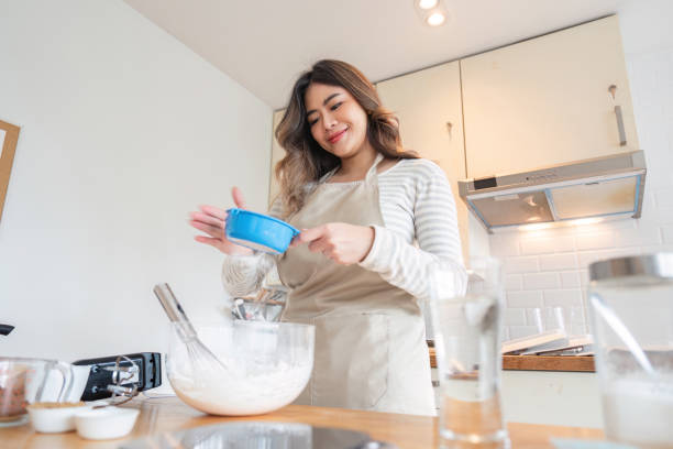 istock Young woman measurement techniques for baking in stylish kitchen 2170922207