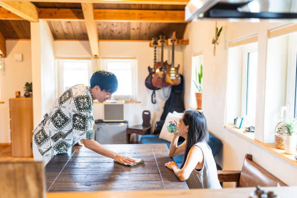istock A young man wiping down the living room table at home 2170923728