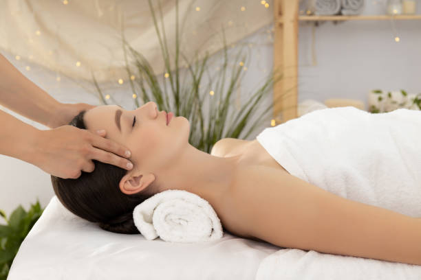 istock Young woman on face massage, masseur hands on light background 2170927943