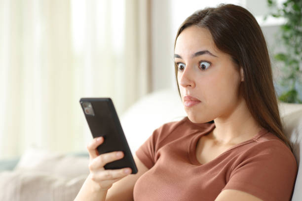 istock Perplexed woman checking smart phone on a couch 2170929964