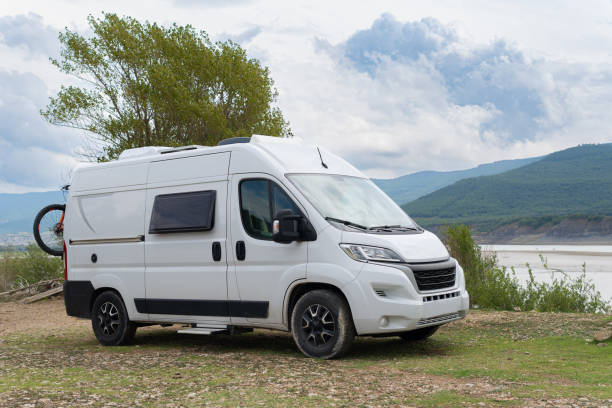 istock modern camper van for vacations by a lake and mountains motorhome trip with bicycles. retractable step down windows folding plates and cooler. 2170930811