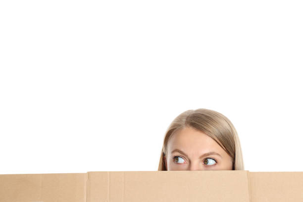 istock Half of woman's face look into something behind cardboard, isolated on white background 2170930905