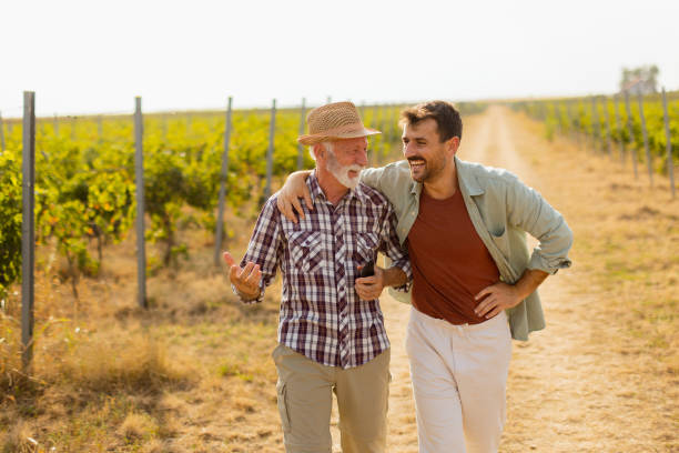 istock Two men stroll through a sunlit vineyard, sharing laughter and stories on a warm afternoon, surrounded by lush green vines 2170931581