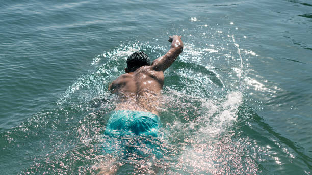 Teenager enjoying the first day on the Sardinia beach. He is enjoying the crystal clear water, running and splashing in the sea.\nShot with Canon R5.