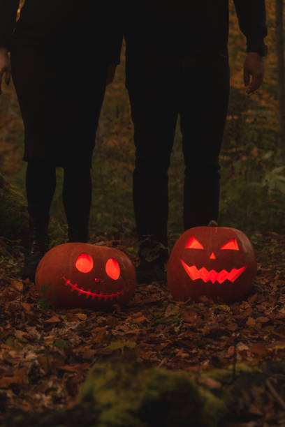 Glowing Halloween Pumpkins in Autumn Forest copy space