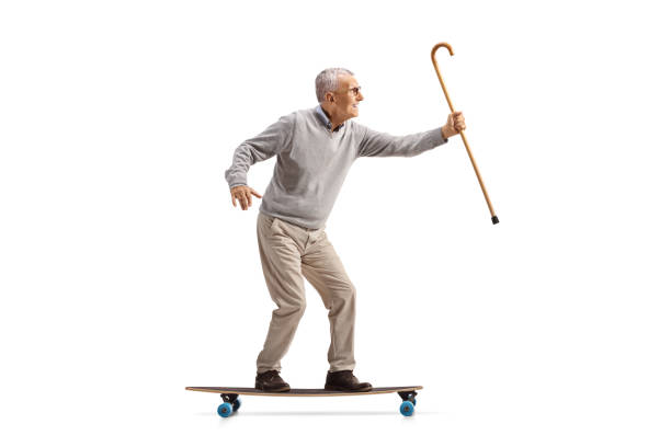 istock Elderly man with a cane riding a longboard 2170937520