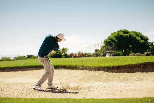 istock Male golfer skillfully showcasing athletic game techniques and concentration escaping sand bunker 2170940356