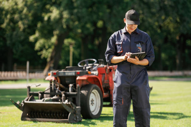 istock In cap, holding digital tablet. Man is with utility tractor with grass cutter and aerator equipment on the field 2170941332