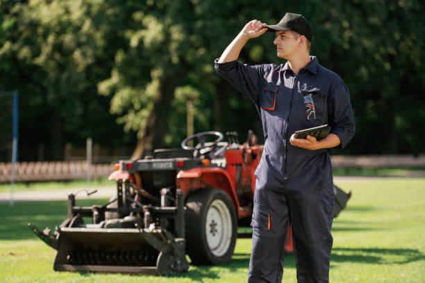istock In cap, holding digital tablet. Man is with utility tractor with grass cutter and aerator equipment on the field 2170941336