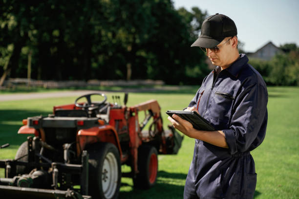 istock Black digital tablet in hands. Man is with utility tractor with grass cutter and aerator equipment on the field 2170941414