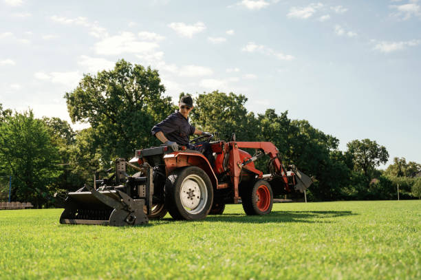 istock Loan work. Man is with utility tractor with grass cutter and aerator equipment on the field 2170941449