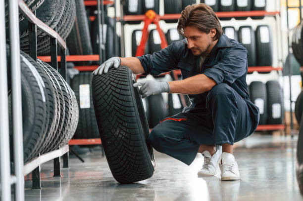 istock In professional uniform. Man is in the tire fitting car service 2170942173