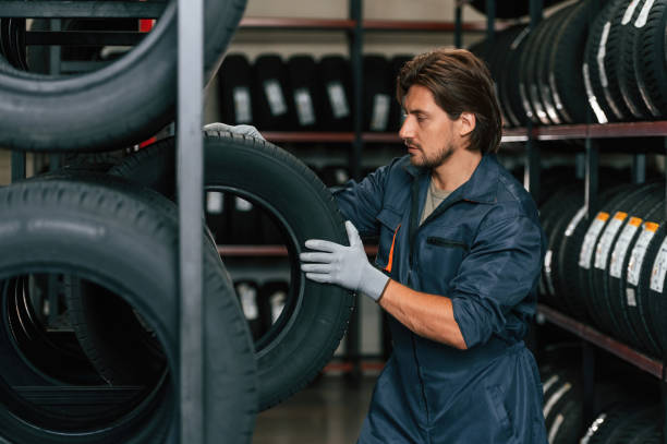 istock Strong worker is with tire. Man is in the tire fitting car service 2170942174