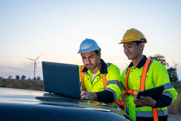 istock Diverse ethnicity male technicians working in the wind turbines field. Innovation engineer men use laptop computer work to develop environmental renewable clean energy outdoors at windmill power farm. 2170942194