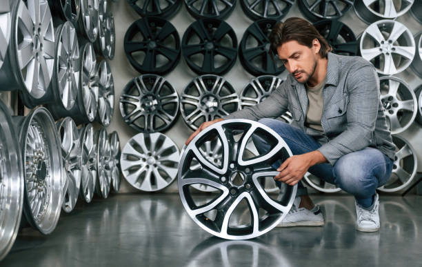 istock Big choice. Man is in the tire fitting car service 2170942382