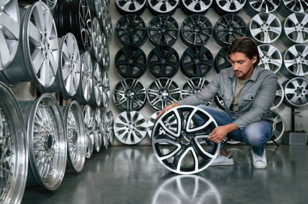 istock Big choice. Man is in the tire fitting car service 2170942390