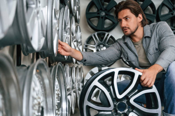 istock Big choice. Man is in the tire fitting car service 2170942442
