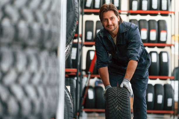 istock Front view, new wheel. Man is in the tire fitting car service 2170942741