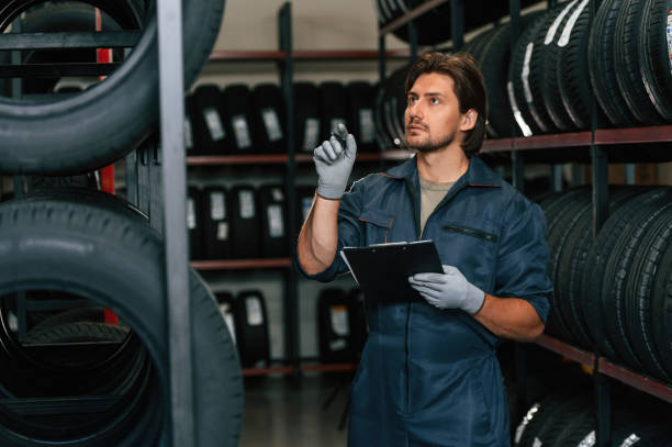 istock Holding black notepad. Man is in the tire fitting car service 2170943584