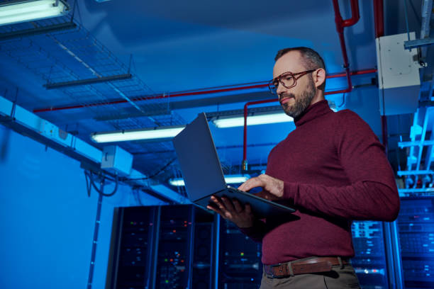 istock A skilled technician working diligently in a modern data center under ambient blue lighting 2170944746