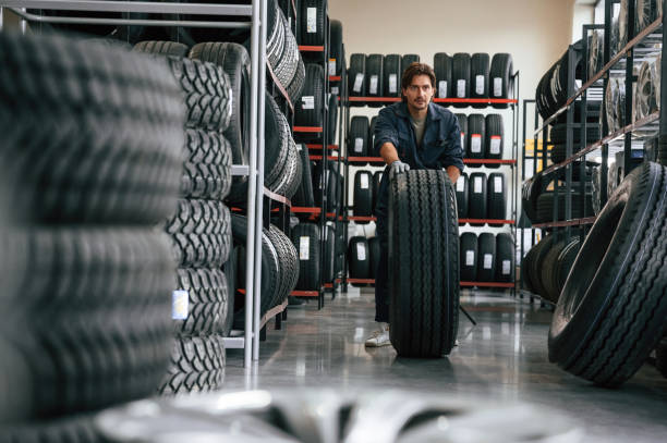 istock Rolling the wheel. Man is in the tire fitting car service 2170945053
