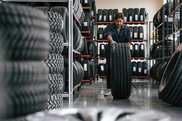 istock Rolling the wheel. Man is in the tire fitting car service 2170945062