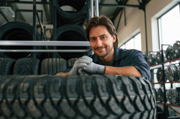 istock View from the front, guy with a tire. Man is in the tire fitting car service 2170945123