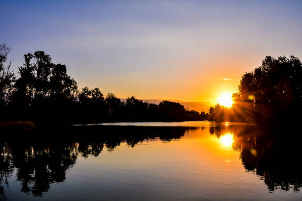 istock A beautiful sunset over a lake with trees in the background 2170945992