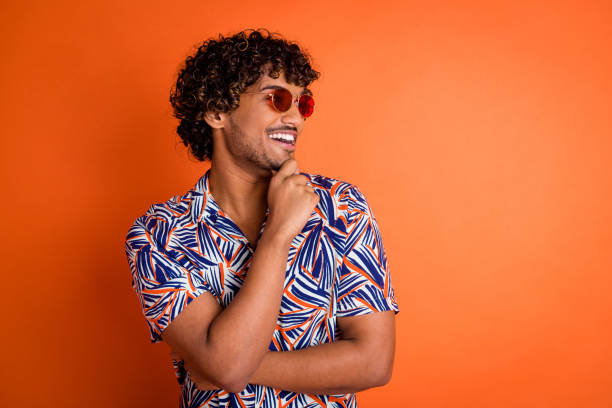 Photo portrait of nice young man sunglass look thoughtful empty space wear trendy colorful outfit isolated on orange color background Photo portrait of nice young man sunglass look thoughtful empty space wear trendy colorful outfit isolated on orange color background. arabian sunglasses stock pictures, royalty-free photos & images