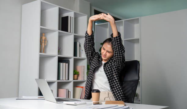 istock Young Business Woman Stretching and Feeling Tired from Work in Modern Office Environment 2170946285