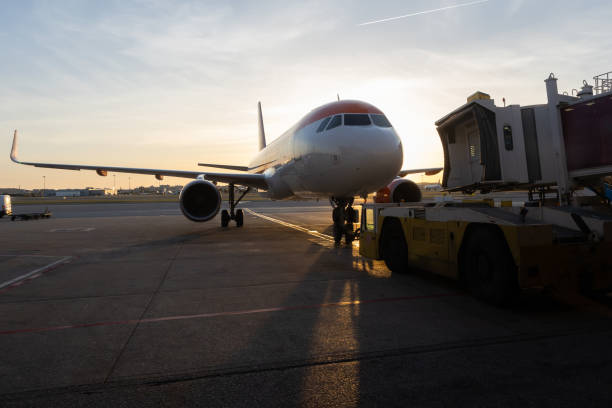 istock A jet bridge connecting to an airplane at sunset 2170947168