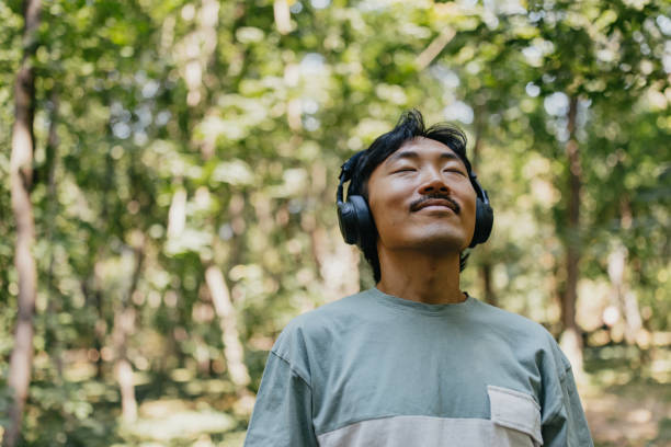istock Serene man with headphones amidst forest greenery. 2170950151