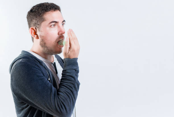 Man using glass to gossip through wall.