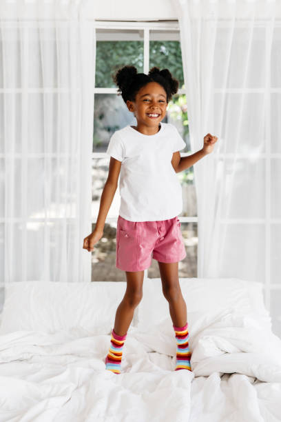 istock Happy black young girl jumping on bed 2170952584